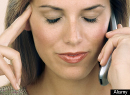 Woman listening on cell phone Fingers to temple. Image shot 2008. Exact date unknown.